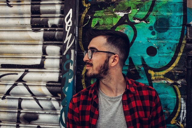Cool guy with glasses in front of graffiti