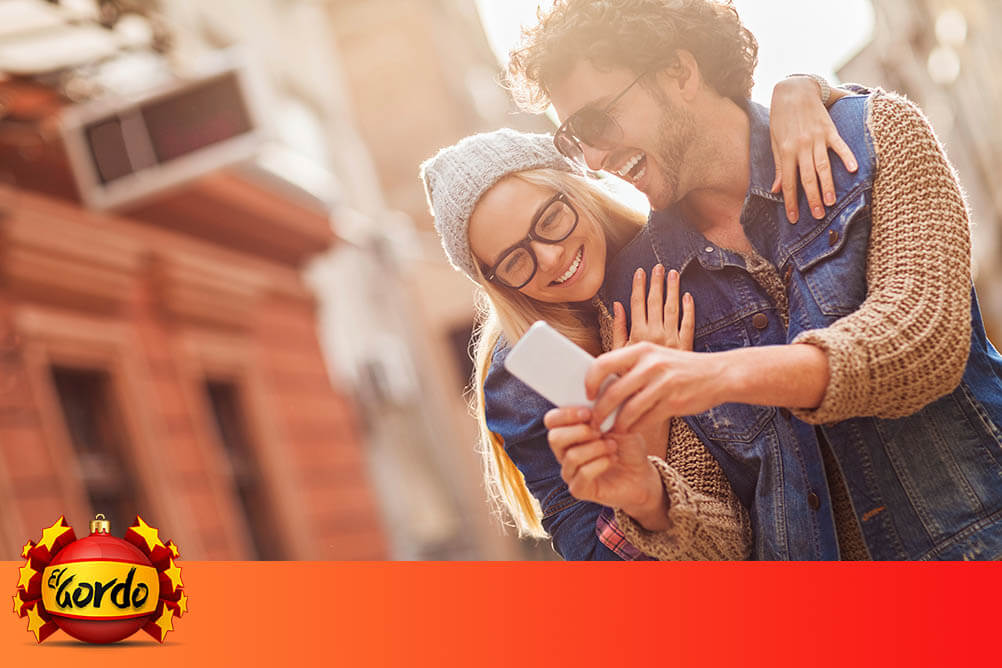 El Gordo Christmas Ads Happy couple watch the latest Spanish Christmas lottery ad on their phone