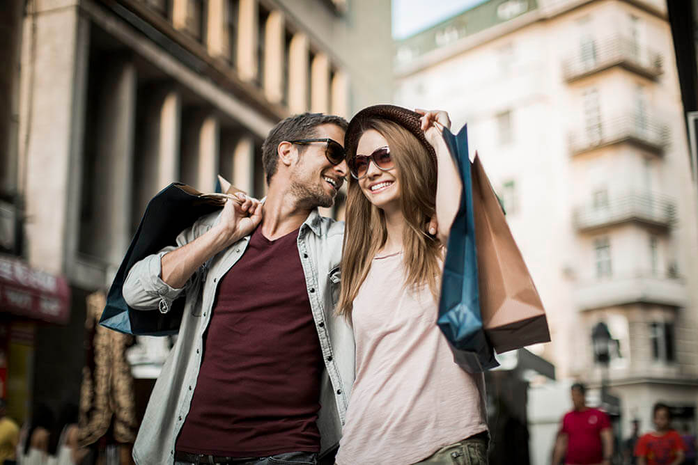 Happy couple walking in city streets after shopping trip