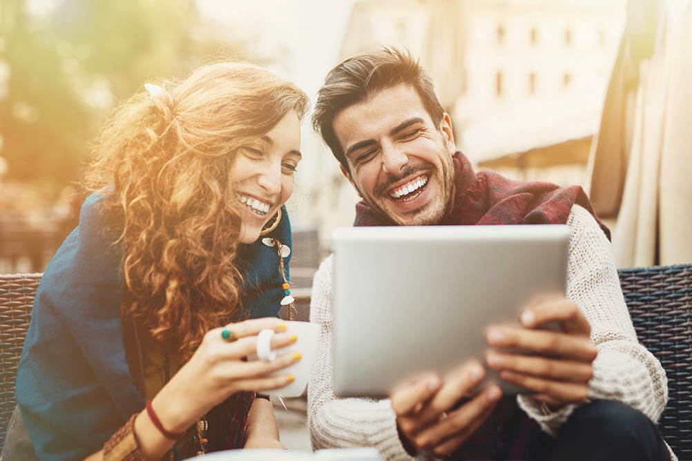 Happy couple looking at tablet