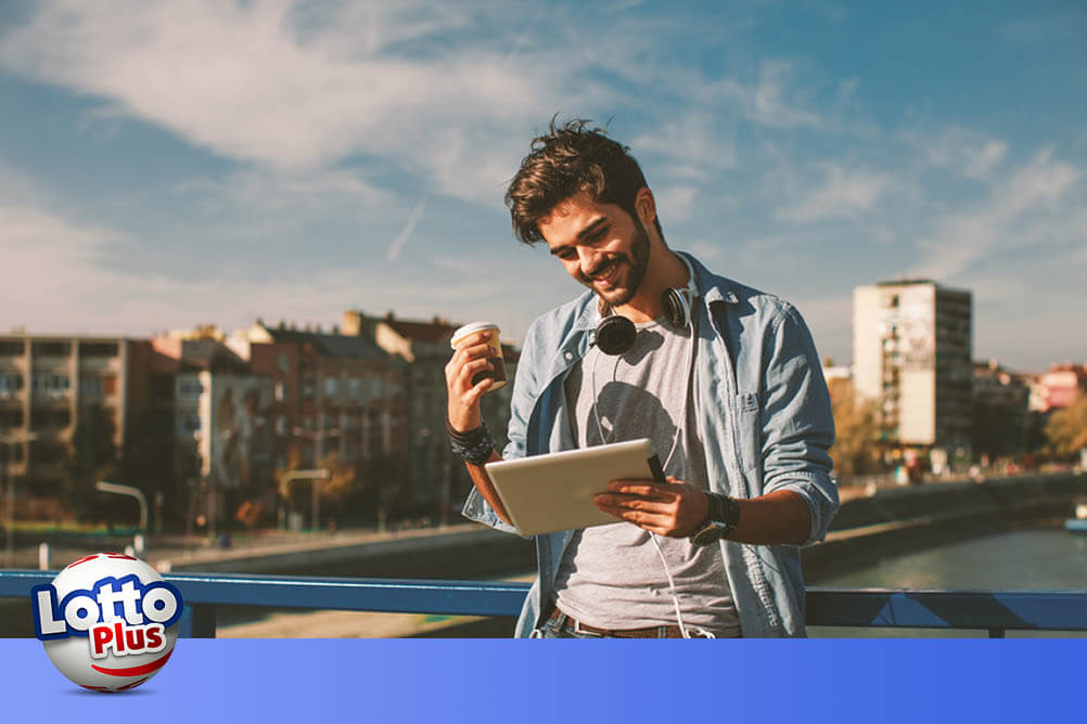 Man smiling and looking at tablet in the city