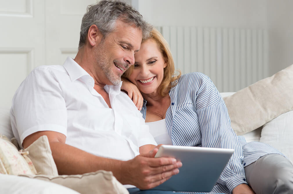 Couple looking at computer screen after verifying their Lottoland account