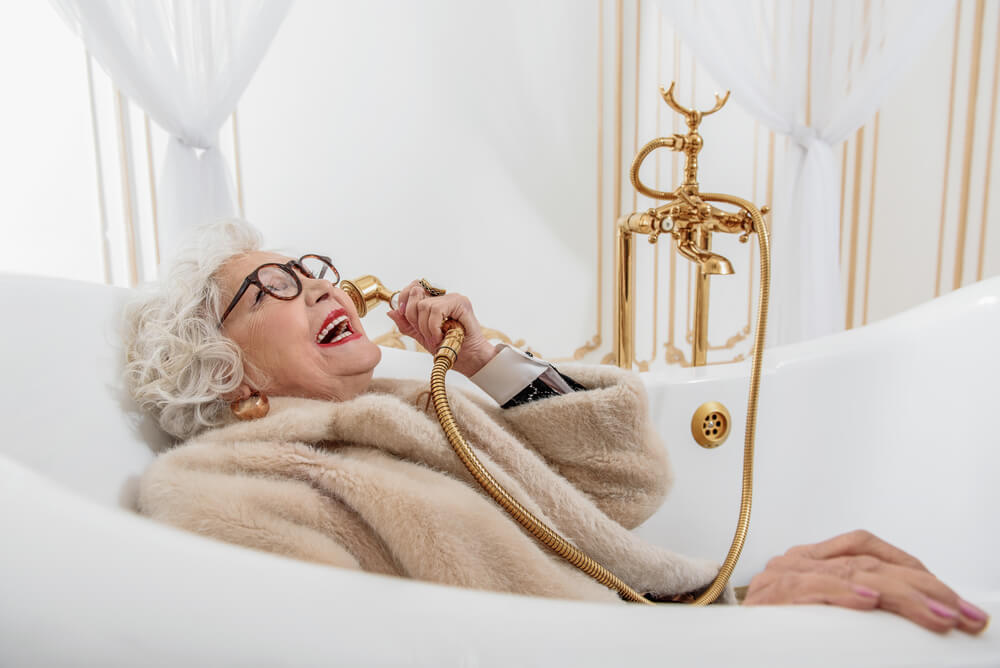 Wealthy older lady lying on couch laughing on the phone