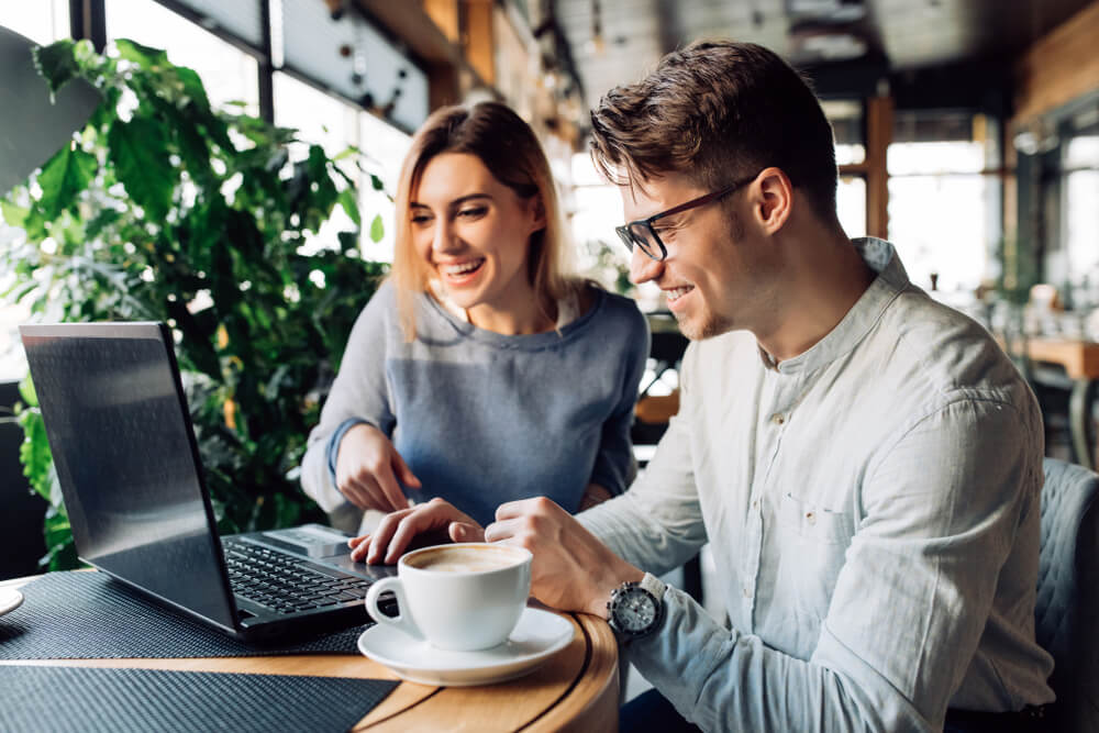 Couple betting on Polish Lotto from their laptop in a cafe