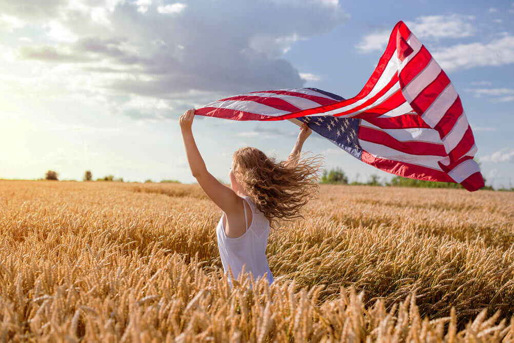 Powerball record jackpot winners Woman running through cornfield waving American flag to celebrate Powerball winners