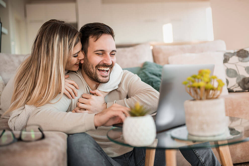 Couple celebrate winning from lottery betting on their computer.