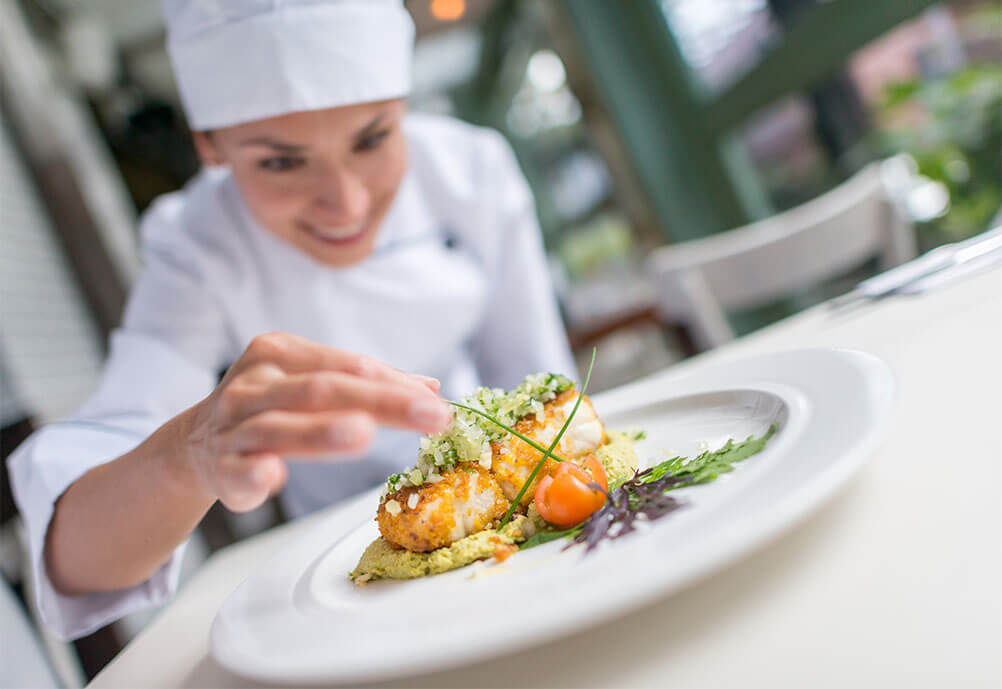 Which country and city has the most Michelin starred restaurants in the world? Smiling female chef prepares a dish at a Michelin star restaurant