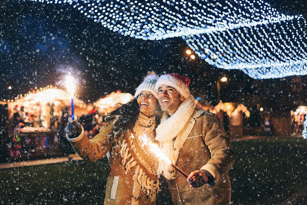 Fun Facts about the Spanish Christmas Lottery, El Gordo A couple celebrate Spanish Christmas in the snow under Christmas lights