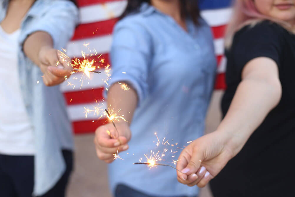 British Lottolander wins big on Powerball Three people holding sparklers in front of an American flag