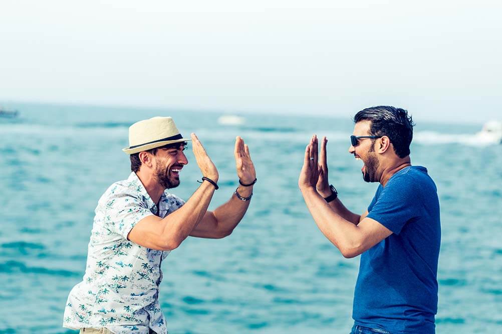 2 friends giving high fives by the sea awesome lottery history