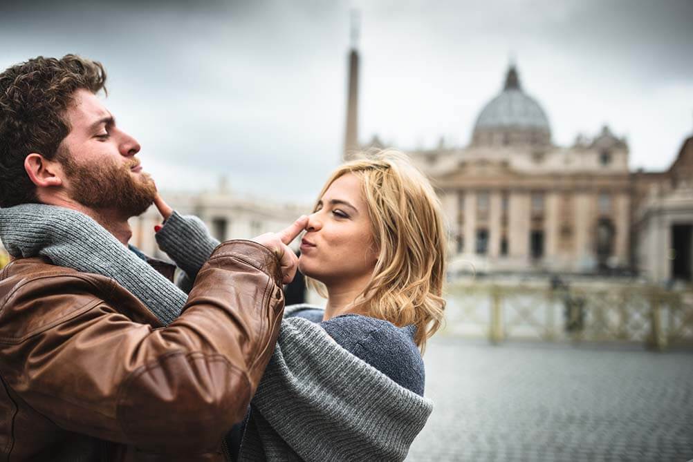 Couple in front of the Vatican wondering if they are more likely to win the lottery or become a saint