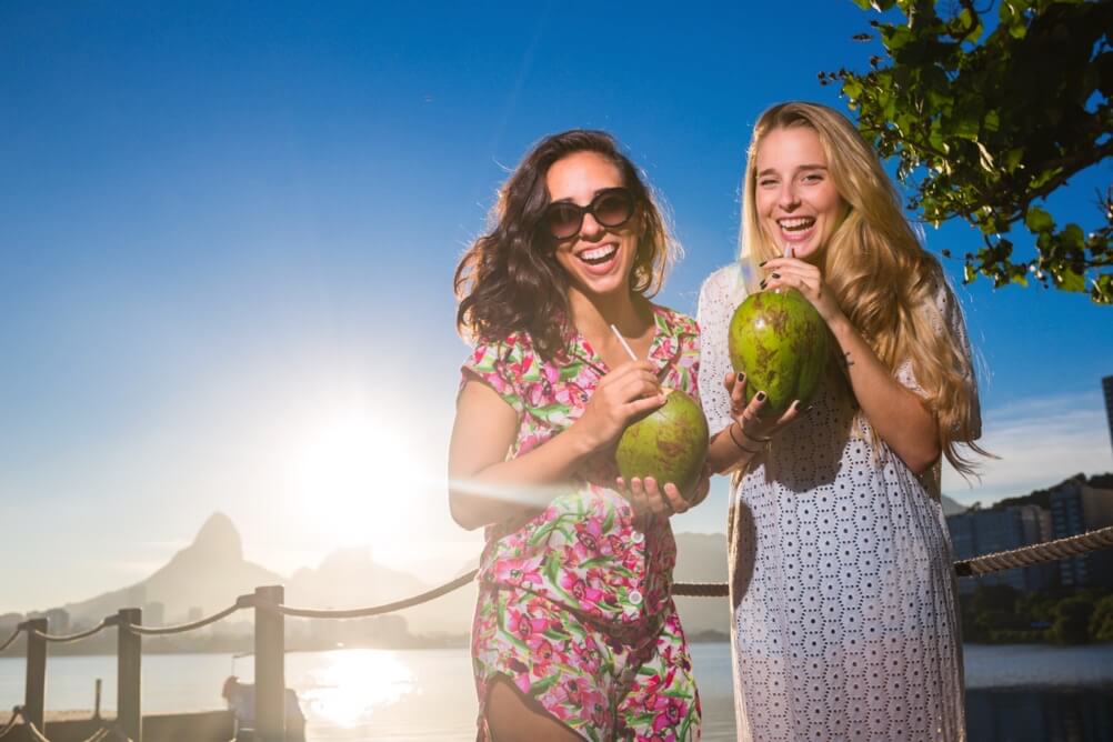 What are the odds of being killed by a coconut? Two women drinking from coconuts on the beach