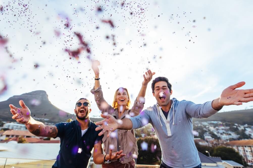 Three friends celebrating with confetti the biggest lottery winners