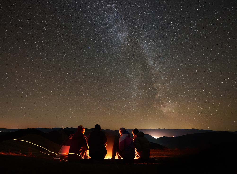 Group of friends under the stars watching for meteors