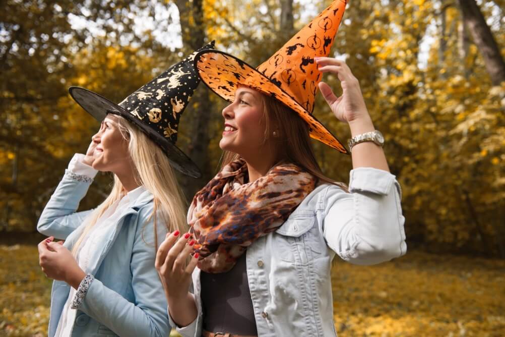 Two women with witches hats waiting for Halloween