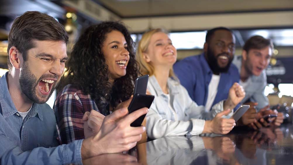 How Lottery Betting Works Friends on their phones checking lottery betting results