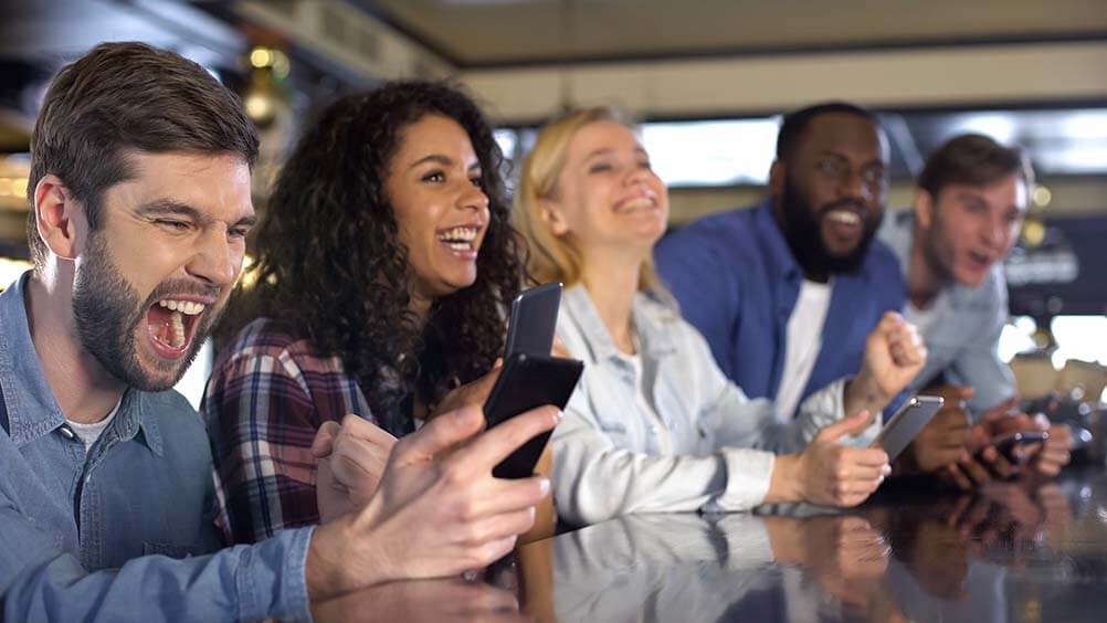 Friends on their phones checking lottery betting results