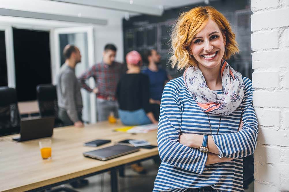 Smiling woman in office happy to not have quit her job after winning the lottery