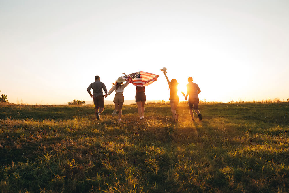 Advantages-of-playing-powerball group-of-friends-running-through-field-with-american-flag