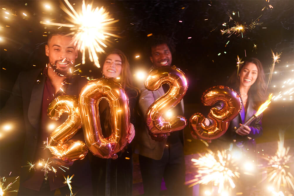 Group of friends with balloons celebrating New Year's Eve lottery Mega 2023