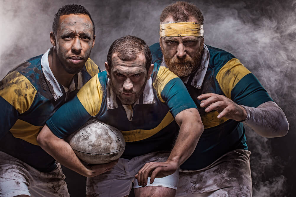 Three rugby players staring at the camera, hoping you know how to bet on rugby in South Africa.